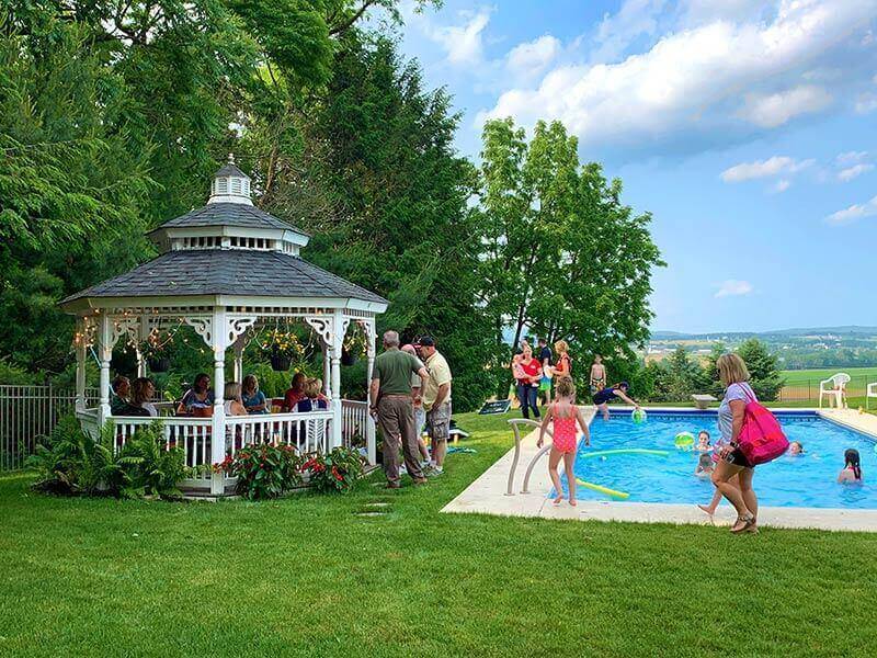 family enjoying outdoor gazebo next to outdoor pool