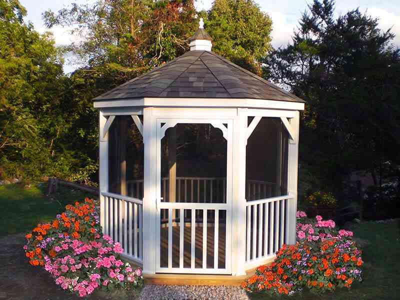 gazebo with screens and flower beds