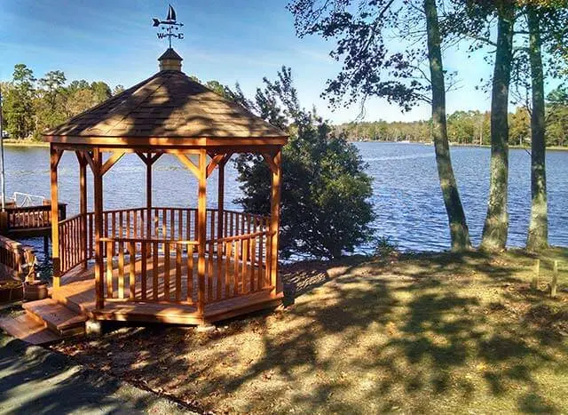 Luxury Wood Gazebo with weathervanes next to a lake