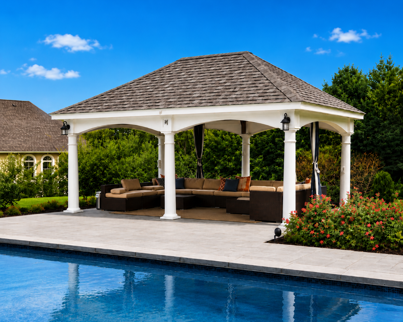 White poolside pavilion with outdoor lounge furniture and landscaped backyard.